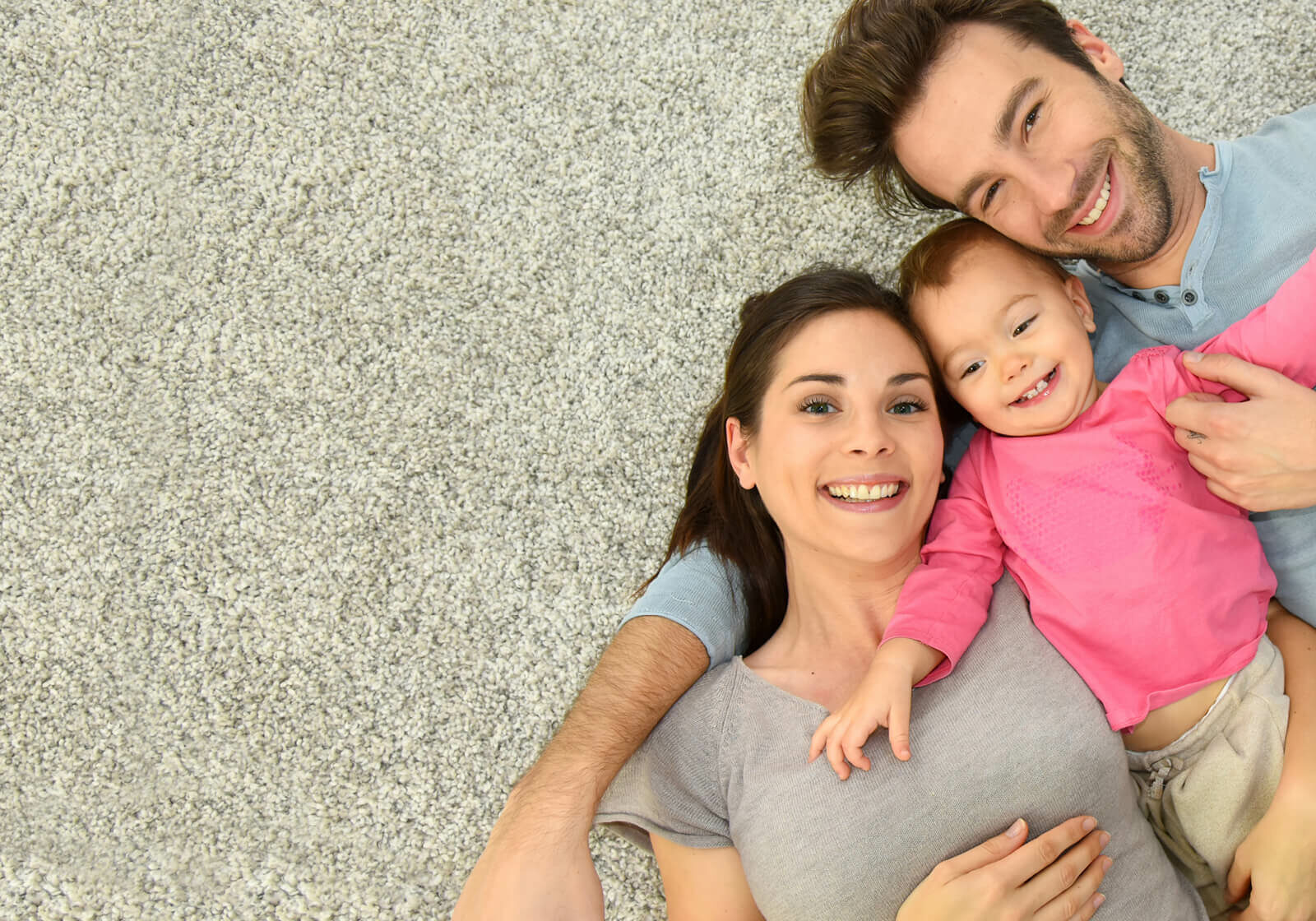 Couple laying on carpet floor with their child | Gateway Floors